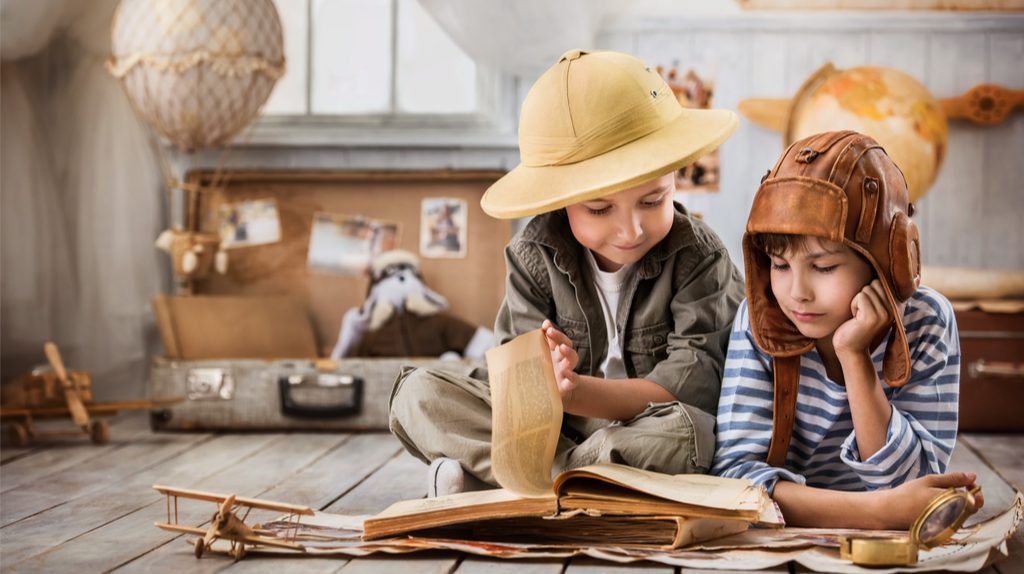 Two kids reading an old book.