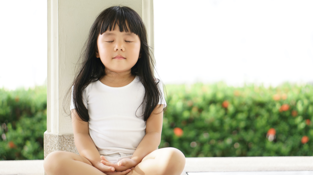 A young Asian girl meditating.